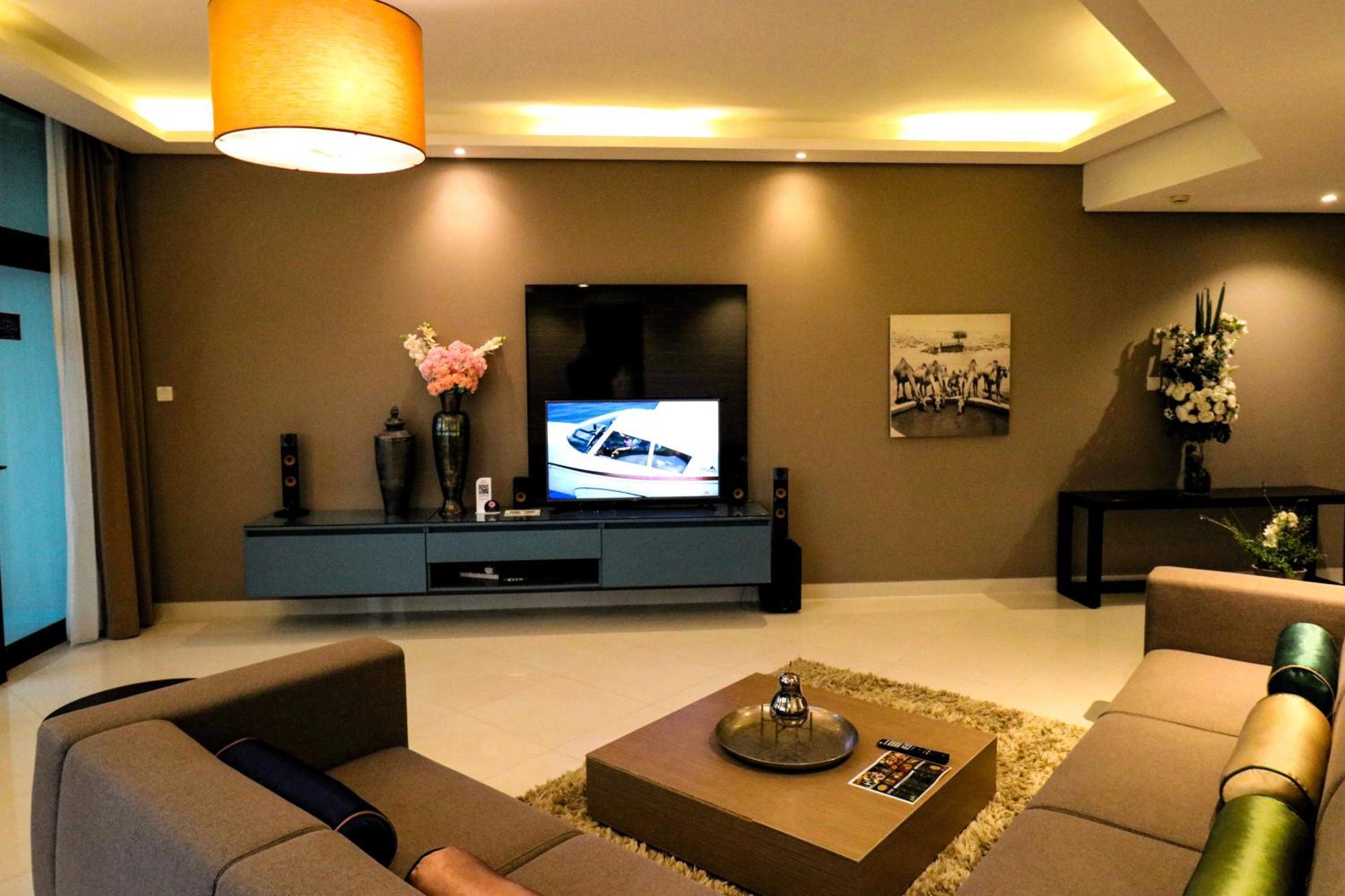 라구나 비치 럭셔리 리조트 앤 스파 마나마 외부 사진 The photo shows a modern living room with a neutral color palette. Key features include:

- A comfortable seating area with a sofa arranged around a coffee table.
- A minimalist coffee table with a decorative item on top.
- A large flat-screen televi
